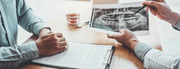 dentist showing a patient their x-rays after jaw injuries